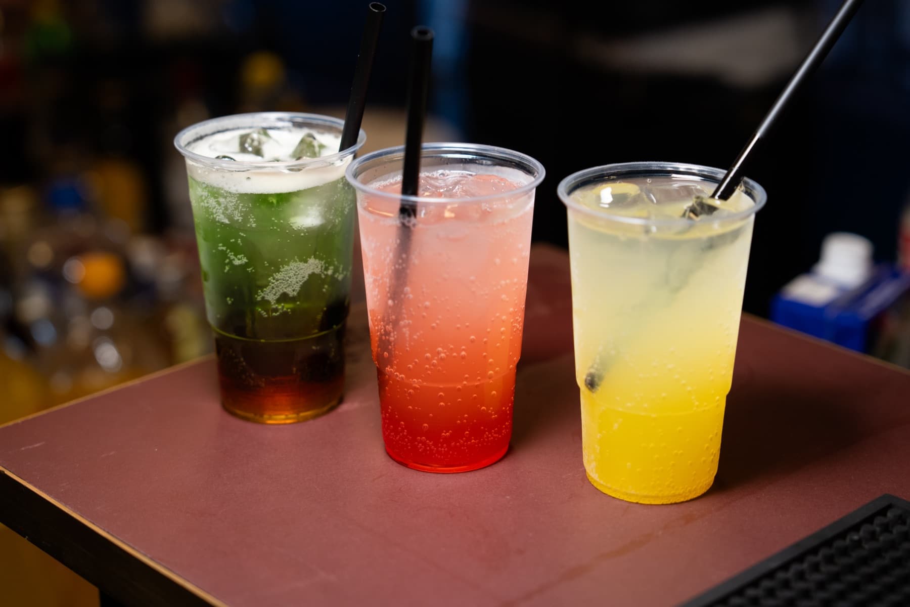 Tre farverige drinks på bardisken