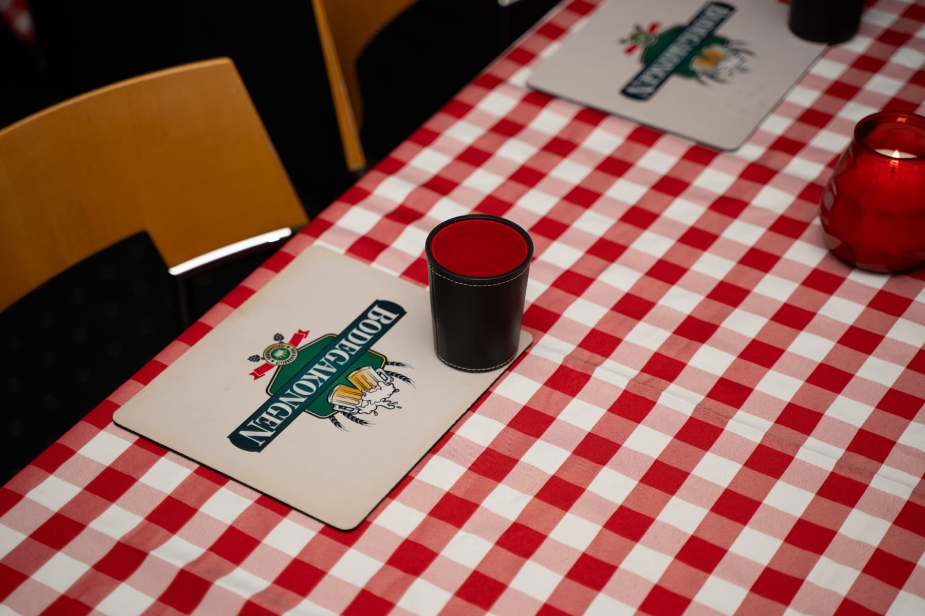 Bord med ternede duge, terninger og raflebægre klar til selskabslege